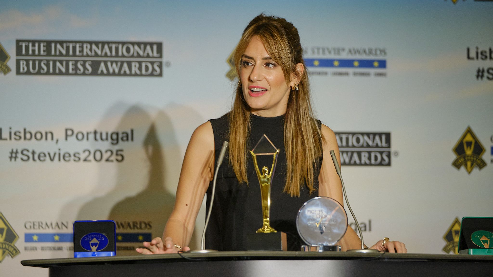Ganador en esmoquin recibiendo su trofeo Stevie en el escenario de los International Business Awards® 2025