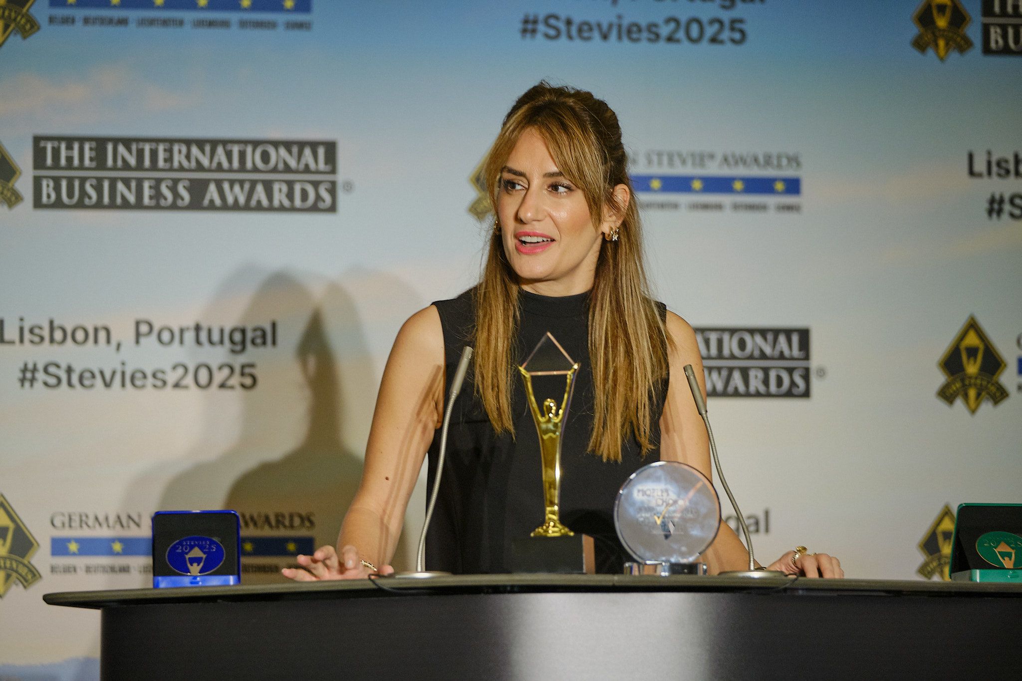 Ganador en esmoquin recibiendo su trofeo Stevie en el escenario de los International Business Awards® 2025