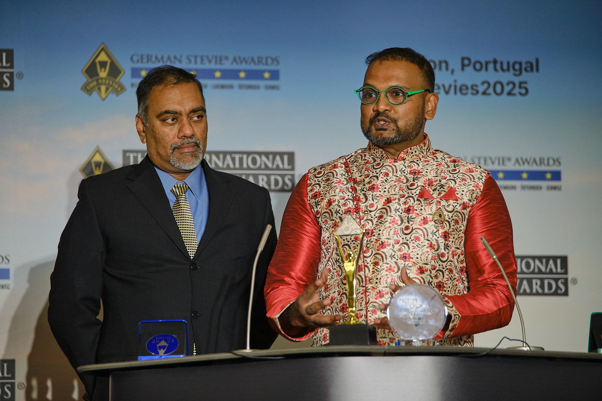 Ganadora emocionada con la mano en el corazón al recibir su trofeo Stevie en los International Business Awards® 2025