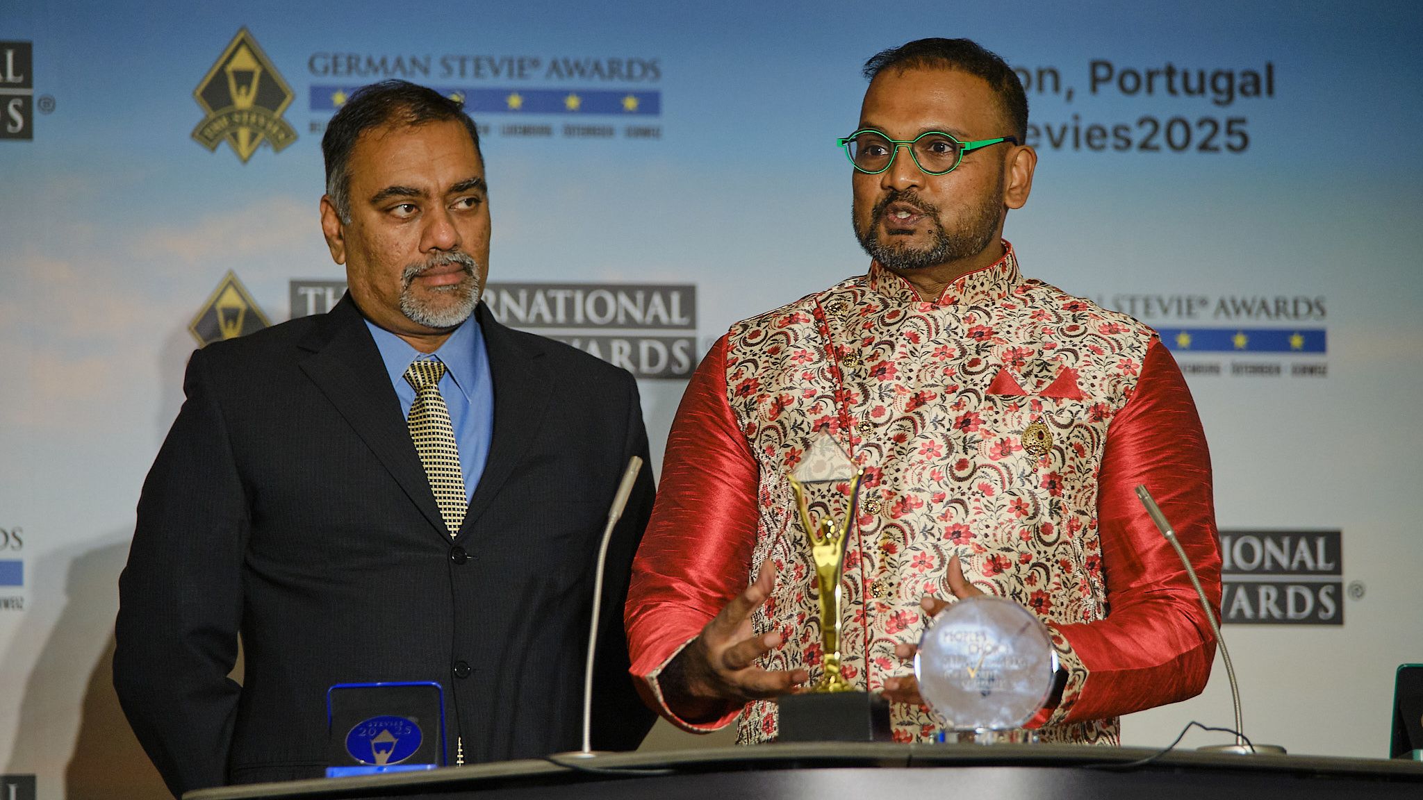 Ganadora emocionada con la mano en el corazón al recibir su trofeo Stevie en los International Business Awards® 2025